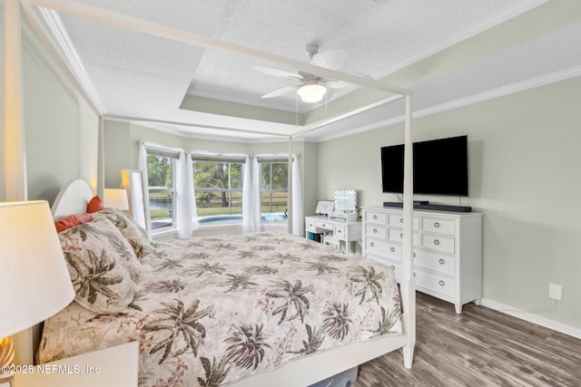 bedroom featuring crown molding, wood finished floors, and a tray ceiling