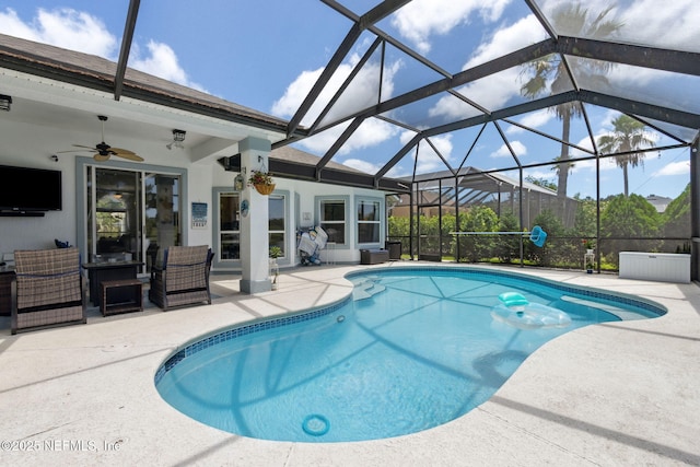 pool featuring an outdoor living space, a ceiling fan, glass enclosure, and a patio area