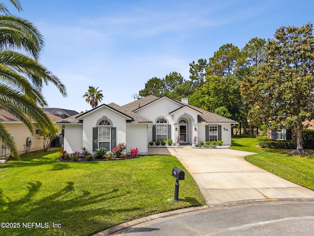 ranch-style home with a shingled roof, stucco siding, driveway, and a front yard
