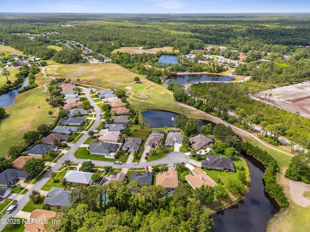 drone / aerial view featuring a water view, a view of trees, view of golf course, and a residential view