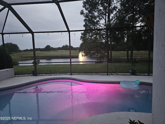 pool featuring a lawn, a lanai, a water view, and a patio