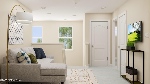 sitting room with baseboards and light carpet