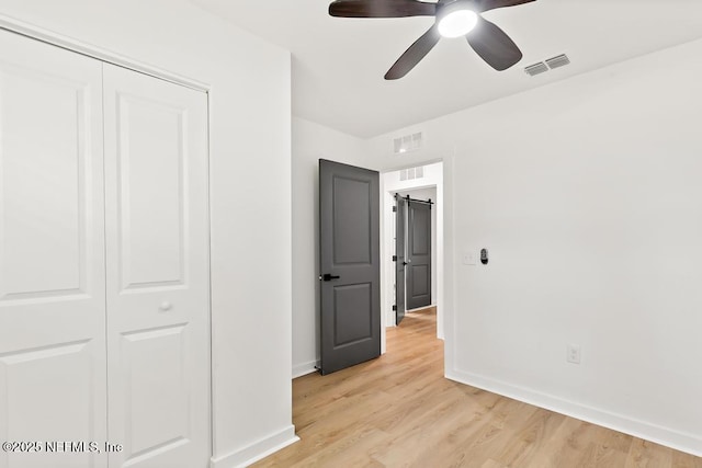 unfurnished bedroom featuring baseboards, visible vents, light wood-style flooring, and a closet