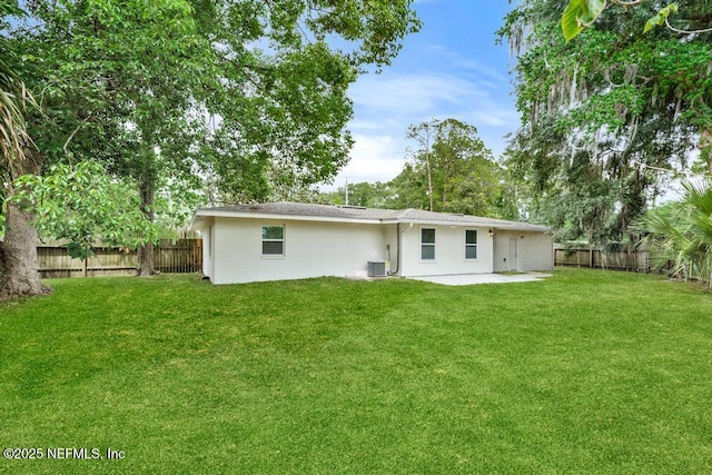 rear view of property with a lawn, a fenced backyard, and a patio area