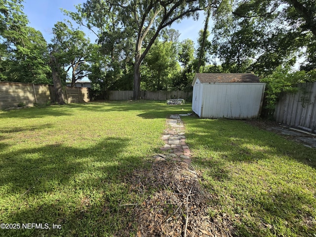 view of yard with an outdoor structure, a fenced backyard, and a storage shed