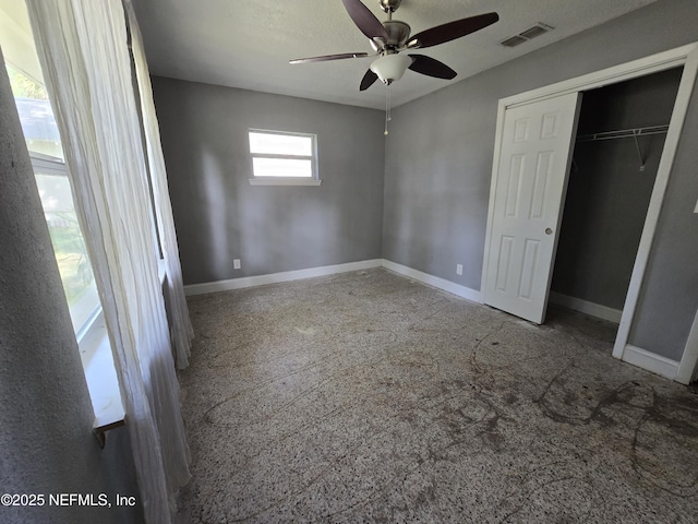 unfurnished bedroom featuring baseboards, visible vents, ceiling fan, and a closet