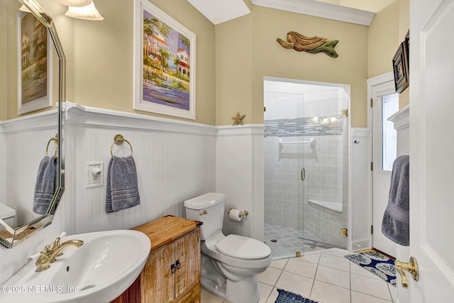 3277 Sequoyah Cir, Saint Johns, FL 32259 - bathroom featuring a sink, toilet, tile patterned floors, a wainscoted wall, and a stall shower