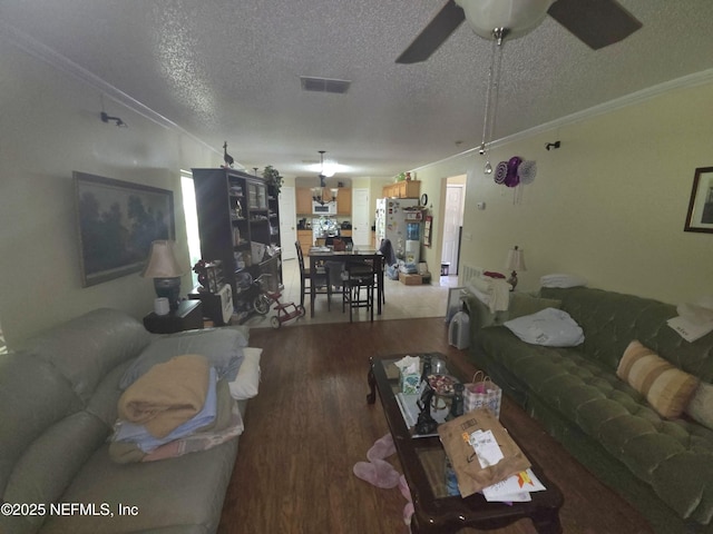 living area featuring crown molding, a textured ceiling, light wood finished floors, and ceiling fan