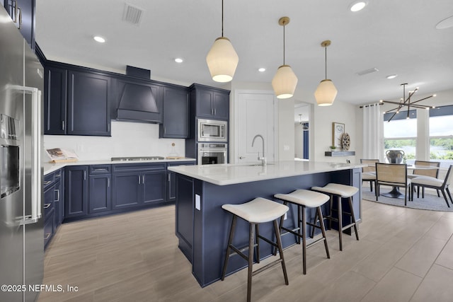 208 Curved Bay Trl, Ponte Vedra, FL 32081 - kitchen with a notable chandelier, appliances with stainless steel finishes, a sink, a kitchen breakfast bar, and custom range hood