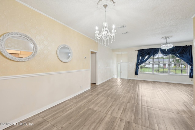 7437 Ortega Hills Dr, Jacksonville, FL 32244 - unfurnished living room with a chandelier, wood finished floors, a textured ceiling, baseboards, and ornamental molding
