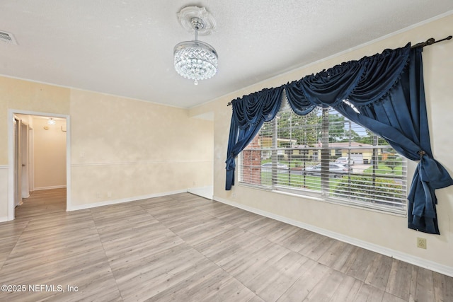 7437 Ortega Hills Dr, Jacksonville, FL 32244 - spare room with a chandelier, baseboards, wood finished floors, a textured ceiling, and crown molding