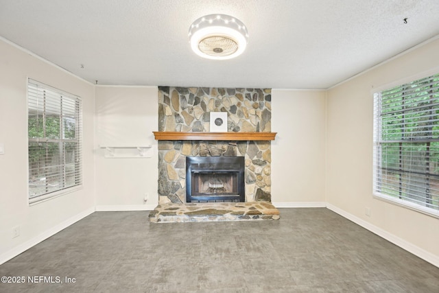 7437 Ortega Hills Dr, Jacksonville, FL 32244 - unfurnished living room with healthy amount of natural light, a textured ceiling, crown molding, a fireplace, and baseboards