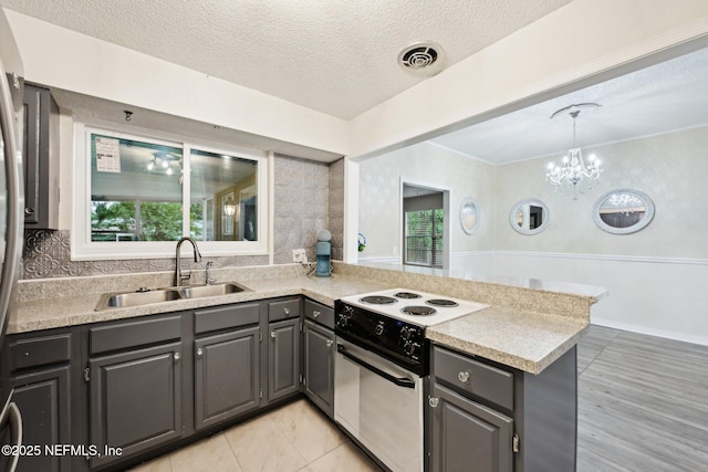 7437 Ortega Hills Dr, Jacksonville, FL 32244 - kitchen with range with electric cooktop, a sink, gray cabinetry, a peninsula, and light countertops