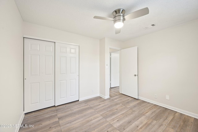 7437 Ortega Hills Dr, Jacksonville, FL 32244 - unfurnished bedroom with light wood-type flooring, a closet, baseboards, a ceiling fan, and a textured ceiling