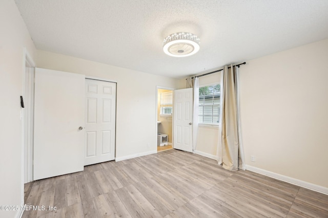 7437 Ortega Hills Dr, Jacksonville, FL 32244 - unfurnished bedroom featuring wood finished floors, a textured ceiling, and baseboards