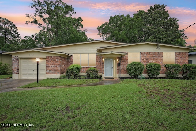 7437 Ortega Hills Dr, Jacksonville, FL 32244 - view of front facade with brick siding, a yard, driveway, and a garage