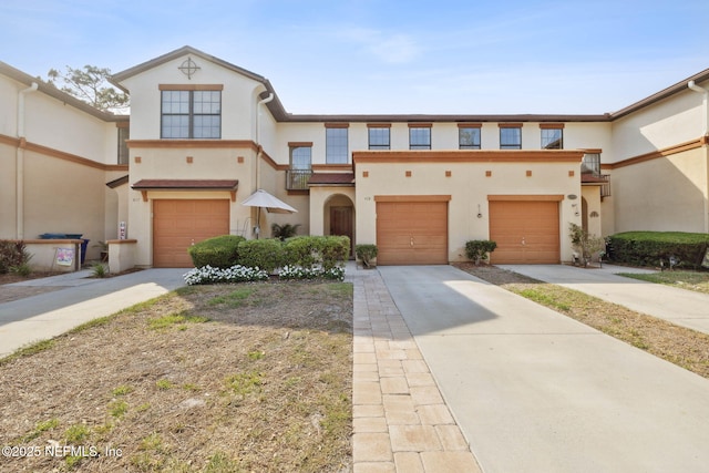 view of front facade with concrete driveway, stucco siding, and an attached garage