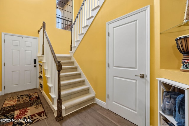 stairway featuring baseboards and wood finished floors
