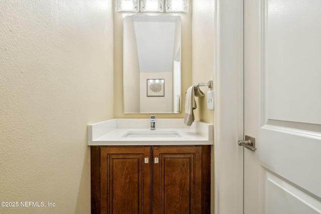 bathroom with a textured wall and vanity