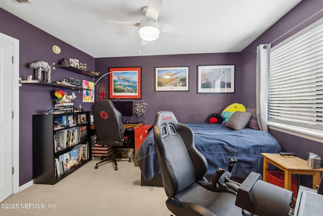 carpeted bedroom featuring ceiling fan, a textured ceiling, and visible vents