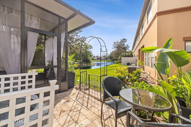 view of patio featuring a water view and central AC
