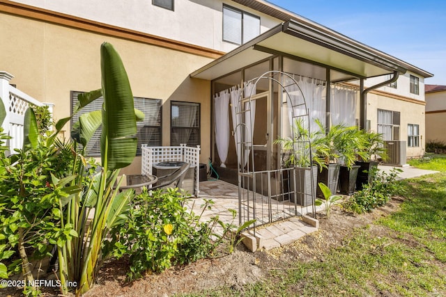 entrance to property featuring a patio area and stucco siding