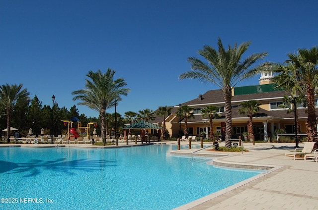 community pool featuring a patio, a gazebo, and playground community