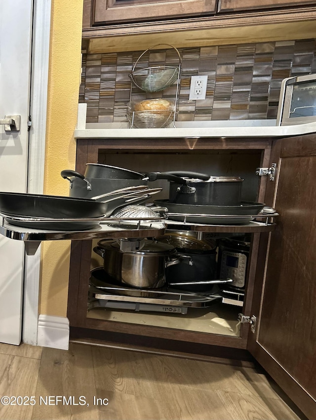 details with light wood-style floors and dark brown cabinets