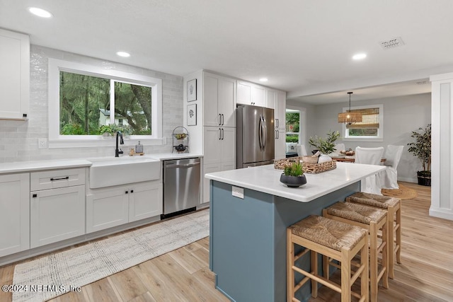 kitchen with visible vents, a sink, tasteful backsplash, and stainless steel appliances