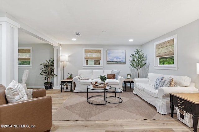 living area with visible vents, recessed lighting, decorative columns, and light wood-style floors