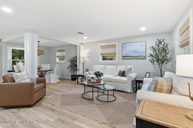 living area with recessed lighting, decorative columns, light wood-style flooring, and visible vents