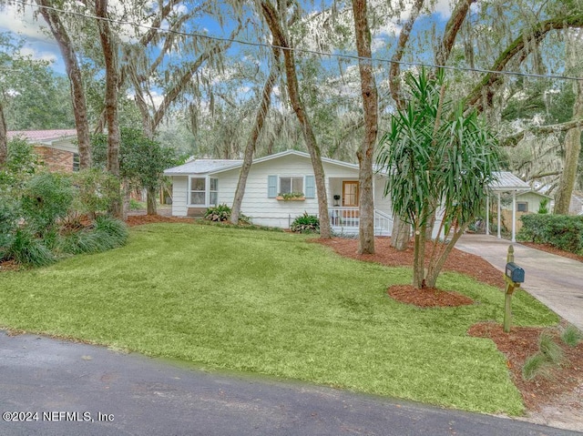 ranch-style home featuring a porch, a carport, a front yard, and concrete driveway