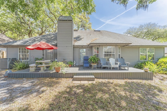 10919 Houndwell Way, Jacksonville, FL 32225 - rear view of house with a deck, a chimney, and roof with shingles