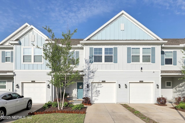 multi unit property with board and batten siding, driveway, and a garage