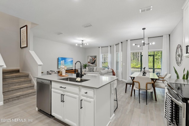 kitchen with a sink, appliances with stainless steel finishes, an inviting chandelier, and open floor plan