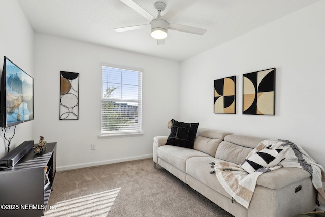 carpeted living room featuring baseboards and a ceiling fan