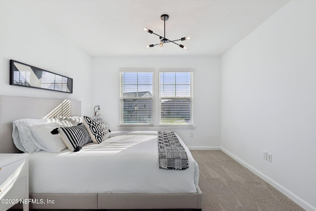 carpeted bedroom with baseboards and a chandelier