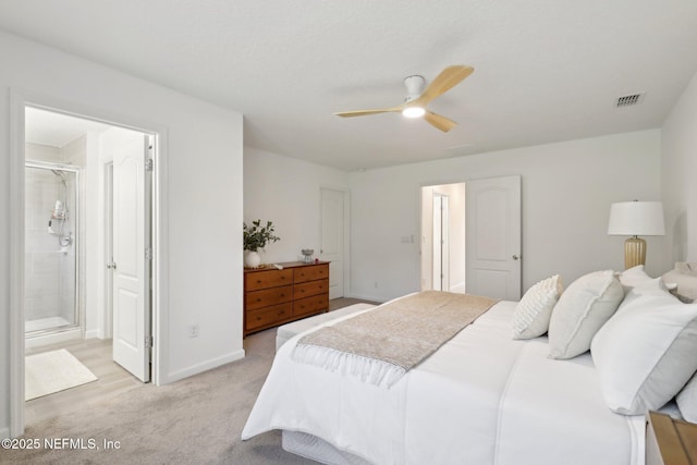 bedroom with ceiling fan, visible vents, baseboards, ensuite bathroom, and light carpet
