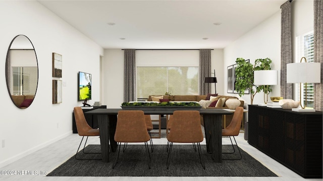 dining room featuring baseboards, light wood finished floors, and a wealth of natural light