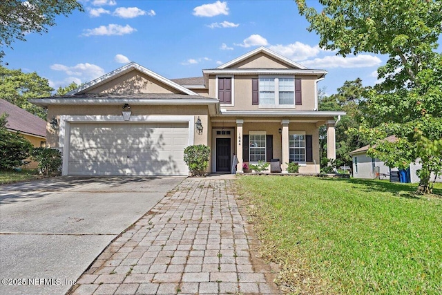 craftsman house featuring a front yard, stucco siding, concrete driveway, an attached garage, and a porch