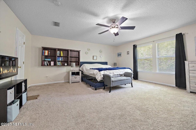 bedroom featuring baseboards, a textured ceiling, carpet, and a ceiling fan