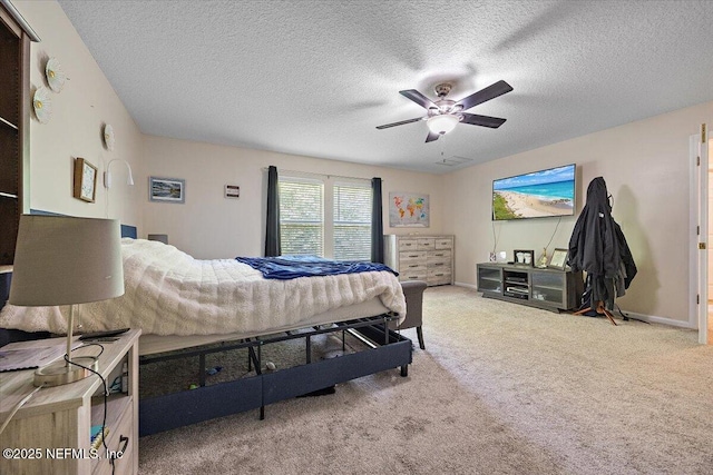 carpeted bedroom featuring baseboards, a textured ceiling, and ceiling fan