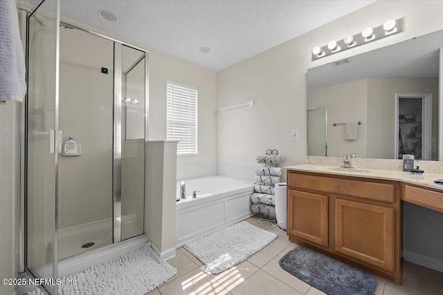 full bathroom with tile patterned flooring, vanity, a textured ceiling, a bath, and a stall shower