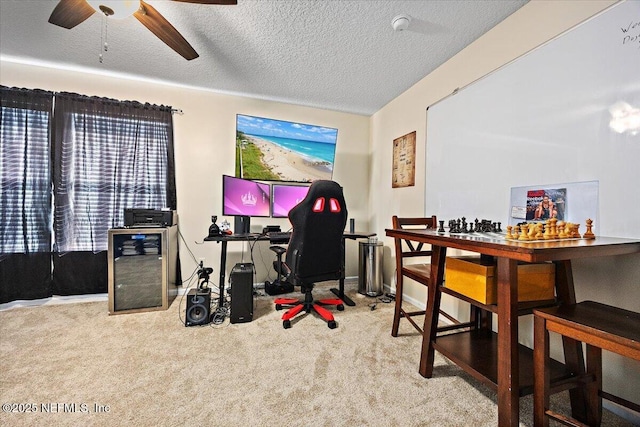 home office featuring a ceiling fan, carpet flooring, and a textured ceiling