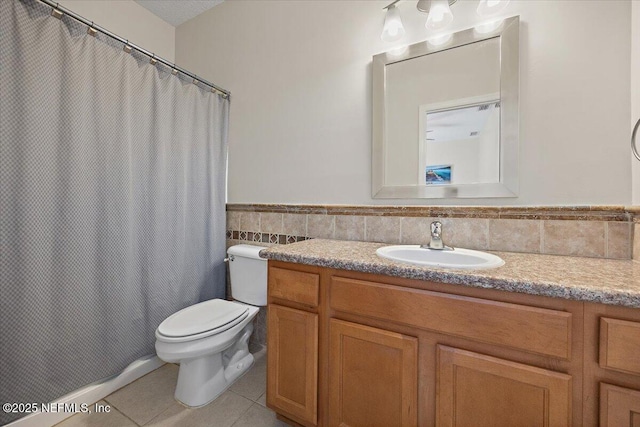 full bath with vanity, wainscoting, toilet, tile walls, and tile patterned floors