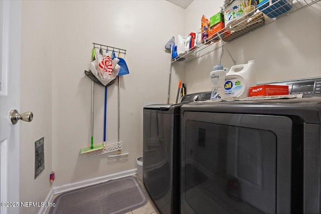 clothes washing area featuring washer and dryer, laundry area, and baseboards