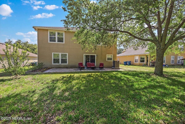 back of property with a patio, stucco siding, central air condition unit, and a yard
