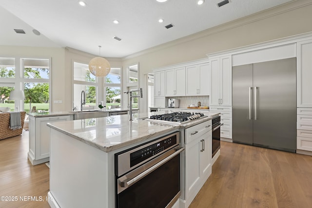 kitchen featuring a kitchen island, stainless steel appliances, recessed lighting, and a sink