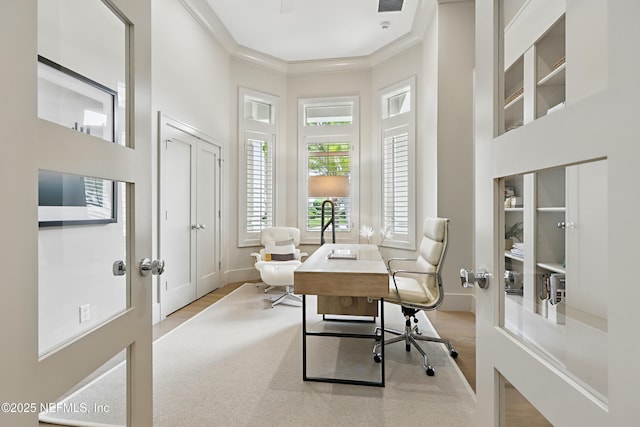 home office with crown molding, visible vents, wood finished floors, and a towering ceiling