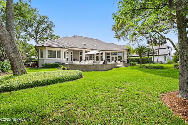 back of property featuring a yard, a patio, a tiled roof, and stucco siding